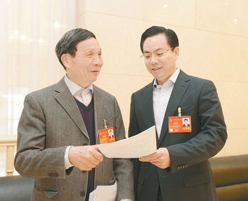 黃伯云代表（左）與劉國(guó)忠代表商討完善《關(guān)于建立戰(zhàn)略性新興產(chǎn)業(yè)國(guó)家創(chuàng)新平臺(tái)》的建議。 本報(bào)記者 張目 攝
